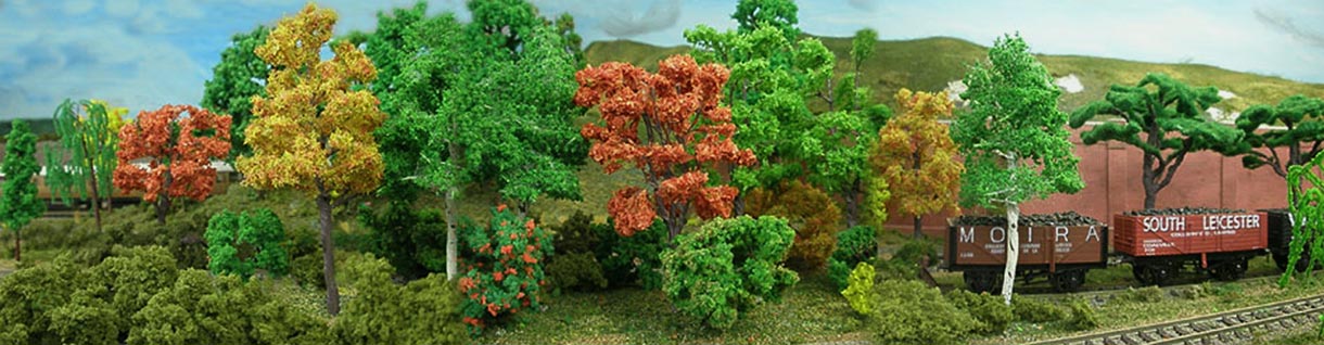 Model railway carriages set amongst trees